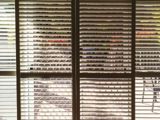 Close-up view of meticulously designed mini blinds in a home setting, showcasing the supreme features and timeless appeal of our window coverings.