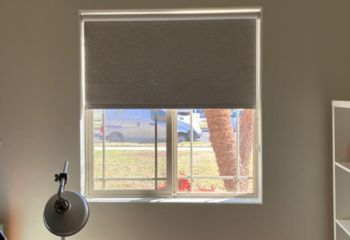 Pull down window shade halfway open in modern Oceanside home office, controlling light.